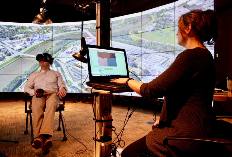 Person wearing IU Indy IT's VR headset with another person controlling what they see on a computer nearby.