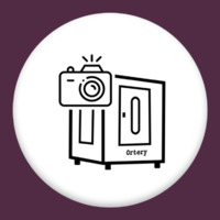 Ortery box with door and a camera icon on top left corner in a white circle with a dark purple background.