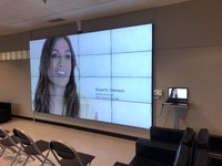 IU Northwest IQ Wall with Woman's headshot on screen with connecting computer available.